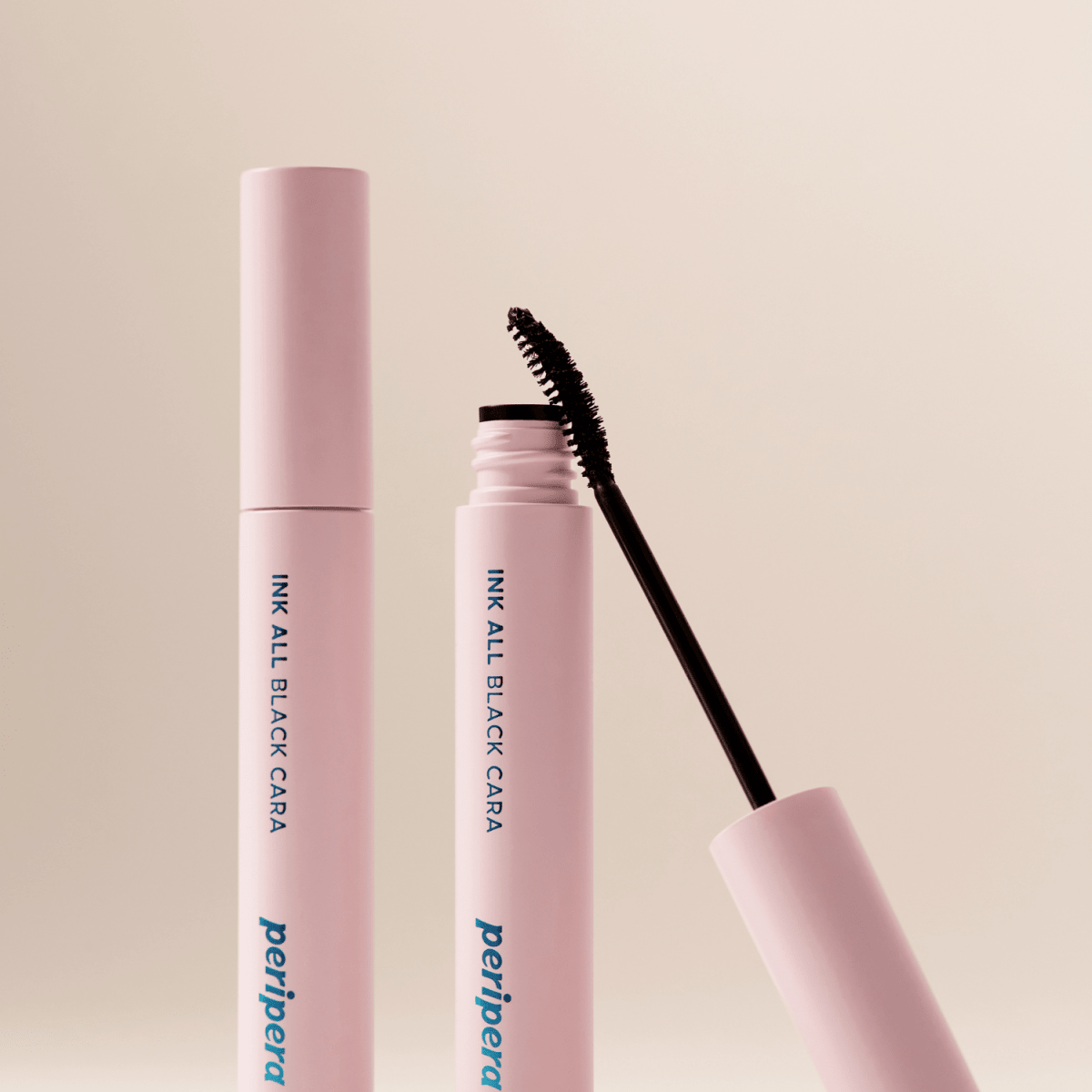 Peripera Ink All Black Cara mascara with evenly coated black lashes and defined curl, showcasing its sleek packaging.
