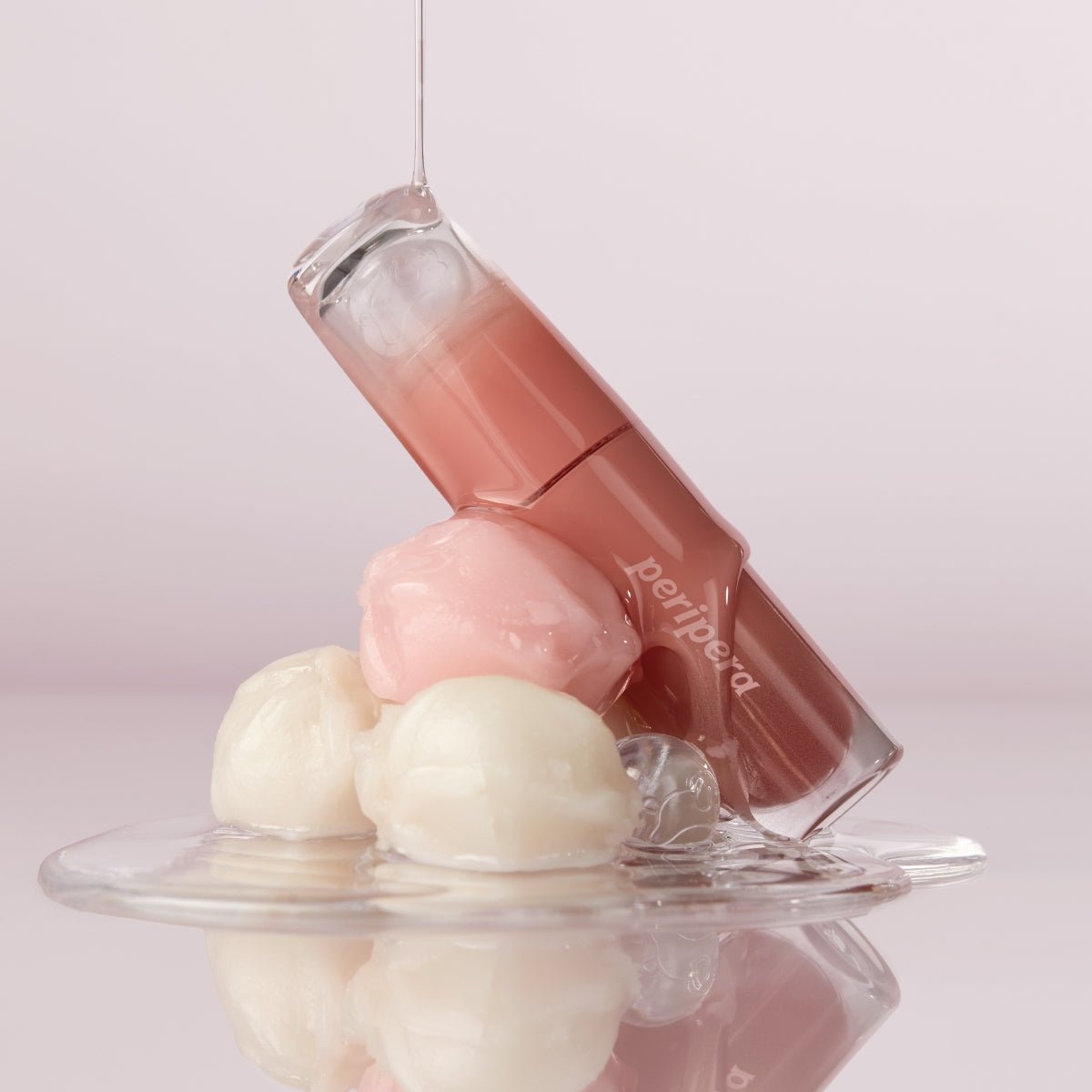 Peripera Ink Mood Glowy Tint lip tint in Tteok Recipe with a glossy, vibrant pink shade displayed on the lips.