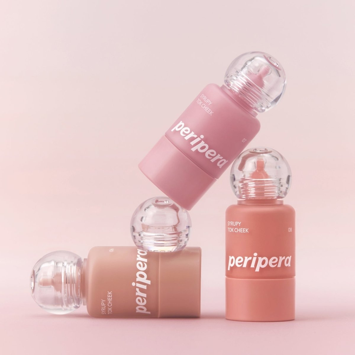 Peripera Syrupy Tok Cheek blush in a soft, glossy pink shade with a smooth, creamy texture and compact packaging.